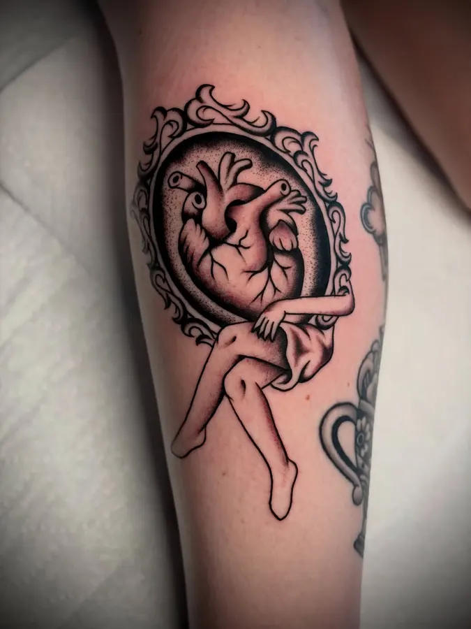 Anatomical heart held by a hand.