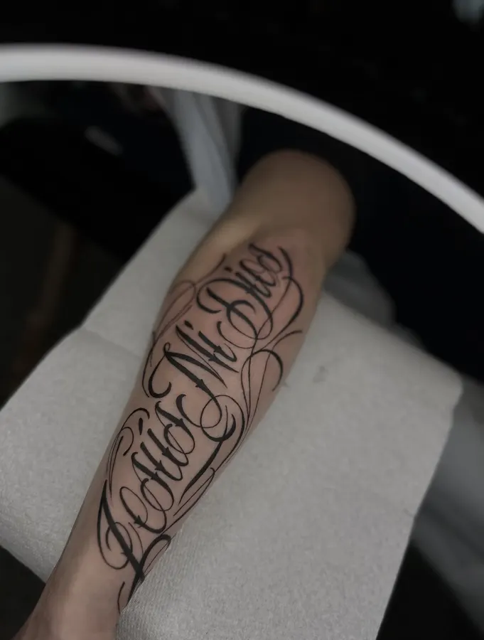 Fine script tattoo on a forearm.
