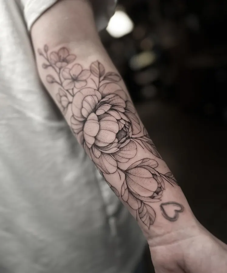 Delicate floral tattoo on a forearm.