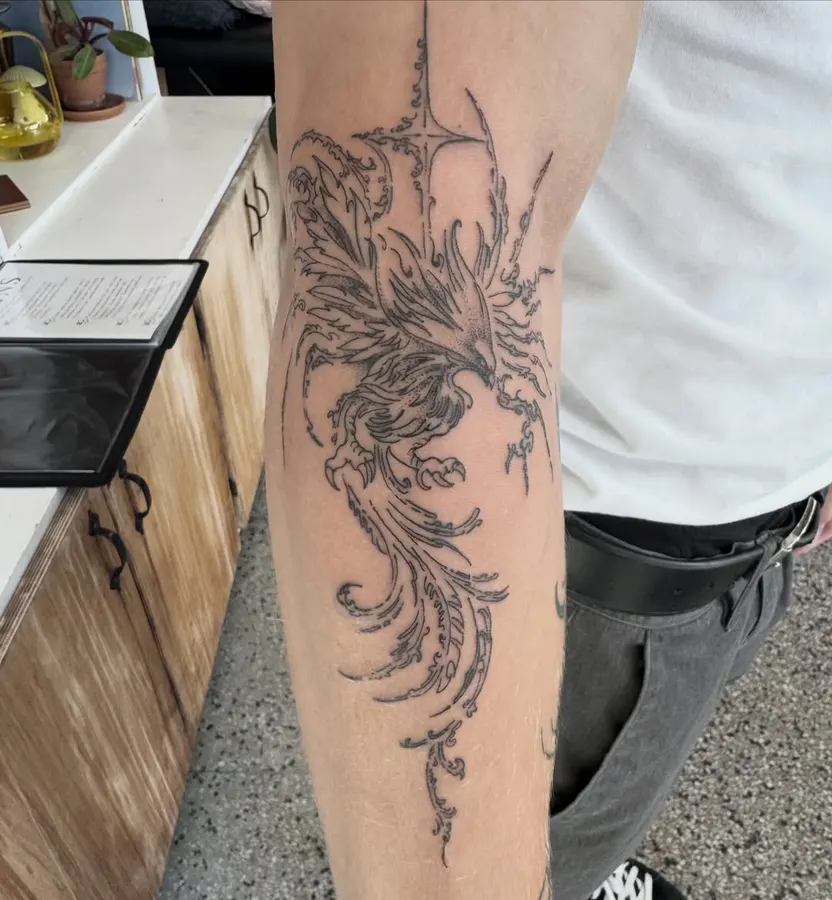 Oiseau aux détails fins tatoué sur un avant-bras.